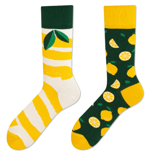 A pair of mismatched socks featuring lemons and citrus slice patterns.